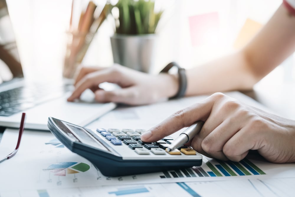 Reviewing household finances with a calculator and laptop